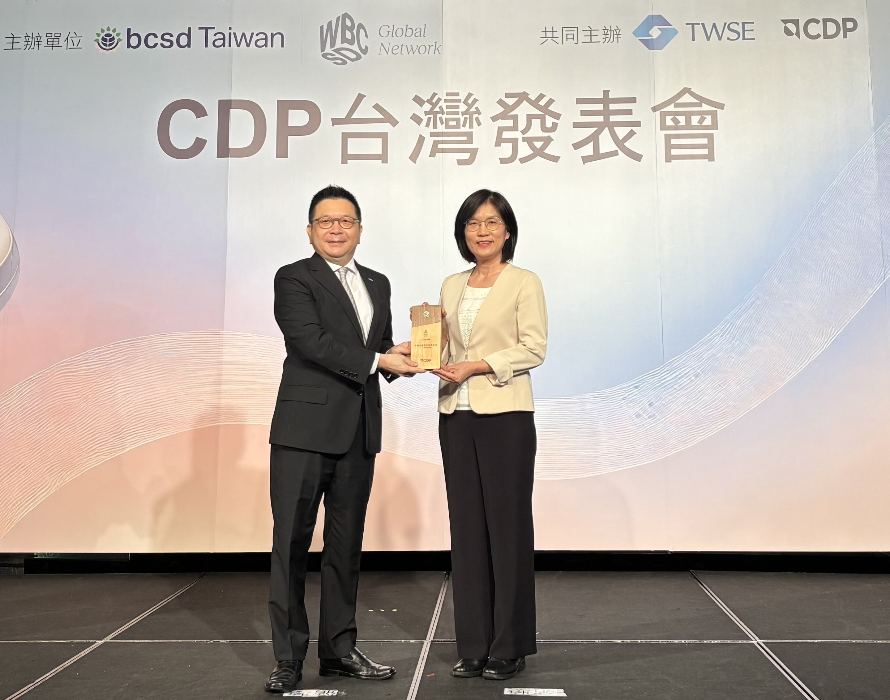 www.樂魚永續成果再獲國際評比肯定，獲頒CDP氣候與水資源雙項領導力評級。今由臺灣證券交易所董事長林修銘（左）頒獎，www.樂魚光電永續長古秀華（右）代表受獎
